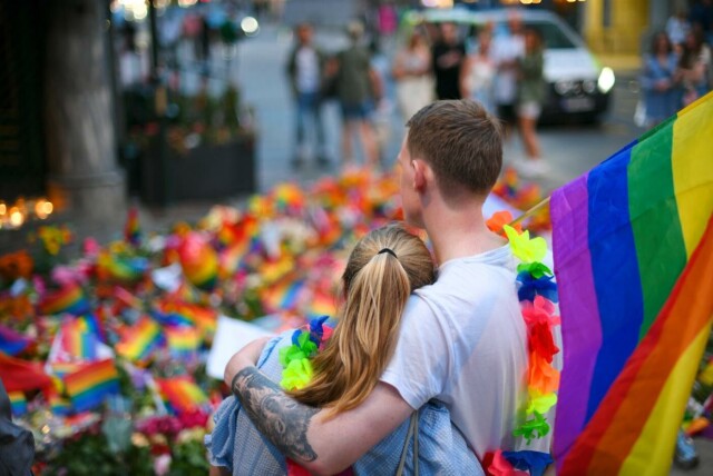 Folk har lagt ned blomster og pride-flagg utenfor London Pub etter at to menn ble drept og 21 personer skadet i en masseskyting natt til lørdag. Foto: Martin Solhaug Standal / NTB. hovedbilde
