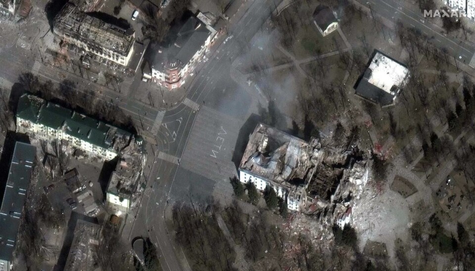 Et satellittbilde som Maxar Technologies offentliggjorde 29. mars, viser at ordet «BARN» var skrevet på russisk i store, hvite bokstaver på bakken utenfor teateret. Foto: AFP / NTB.