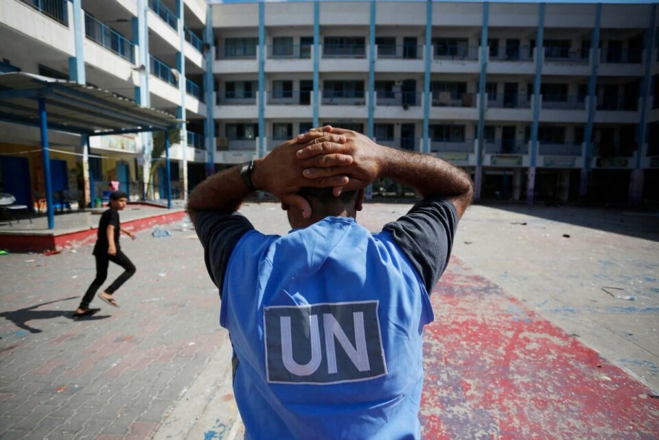 En FN-arbeider i skolegården til en FN-skole i flyktningleiren Al-Maghazi midt på Gaza-stripen. Bildet er tatt dagen etter at flere skal ha blitt drept i et angrep her 18. oktober 2023. Foto: Mohammed Faiq / AFP / NTB