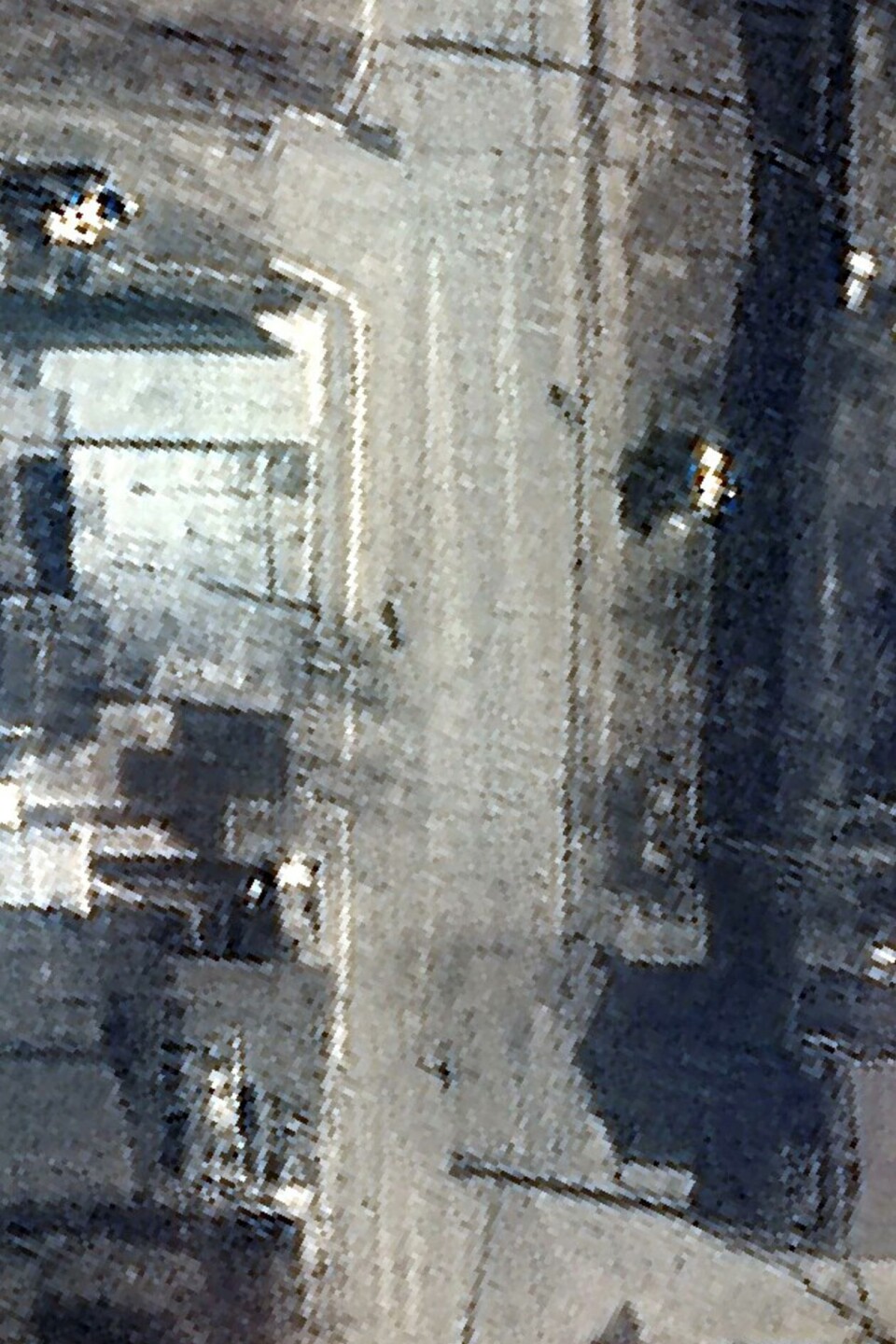 Maxar Technologies har offentliggjort flere satelittbilder som er tatt i Butsja utenfor Kyiv i tidsrommet da russiske styrker kontrollerte området. På dette bildet fra Yablonska-gaten 19. mars, ser man det som fremstår som døde mennesker ligge på åpen gate. Foto: Maxar Technologies / Reuters.