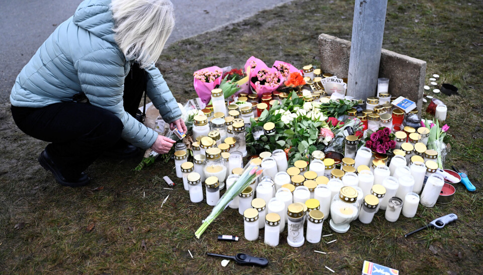 En kvinne legger ned blomster nær skolen i Örebro, der elleve personer mistet livet i masseskytingen.