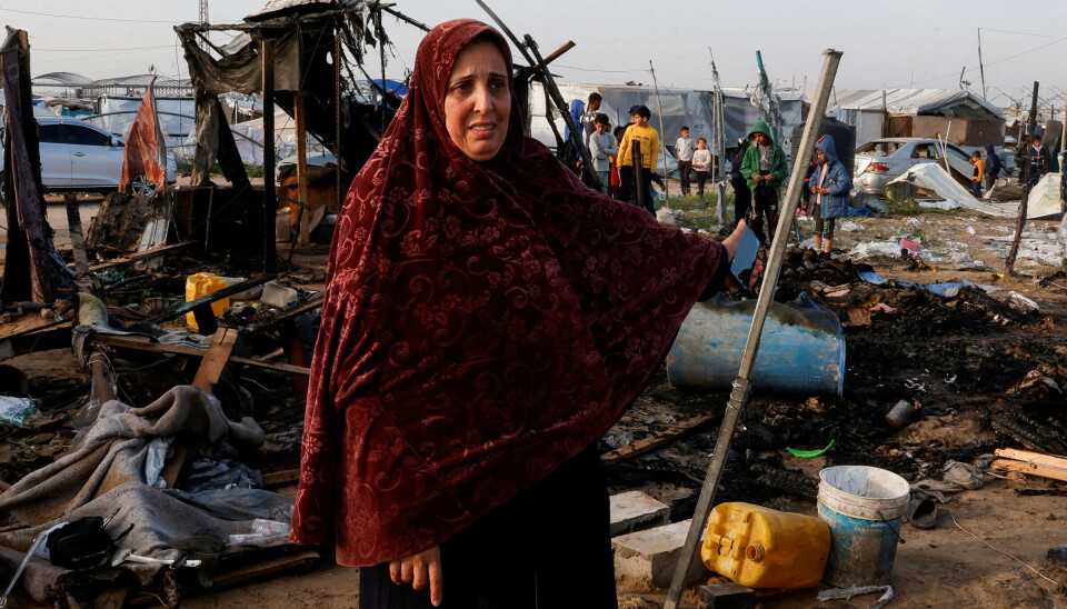 En palestinsk kvinne gestikulerer mens folk undersøker stedet etter et israelsk angrep mot en teltleir i Al-Mawasi-området, i Khan Younis sør på Gazastripen 18. mars 2025.